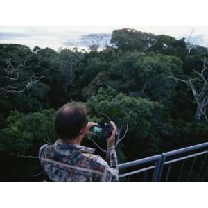 Man with a Camera Enjoys the Forest Canopy from an Observation Deck 